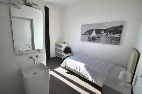 クエルチアネッラにあるHotel Belsoggiornoの白いベッドルーム(ベッド1台、シンク付)