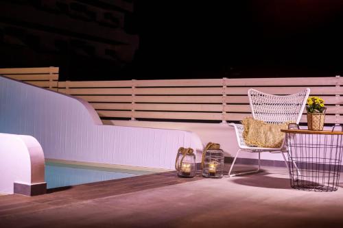 a chair and a table on a balcony at Malibu Boutique Studios & Bungalows in Faliraki