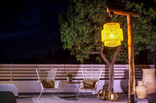 a group of chairs sitting next to a tree at Malibu Boutique Studios & Bungalows in Faliraki