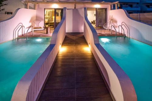 a swimming pool with a water slide in a hotel at Malibu Boutique Studios & Bungalows in Faliraki