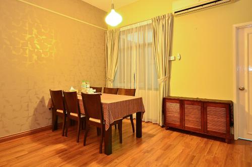 a dining room with a table and chairs and a window at Jetty Suites Apartments in Malacca