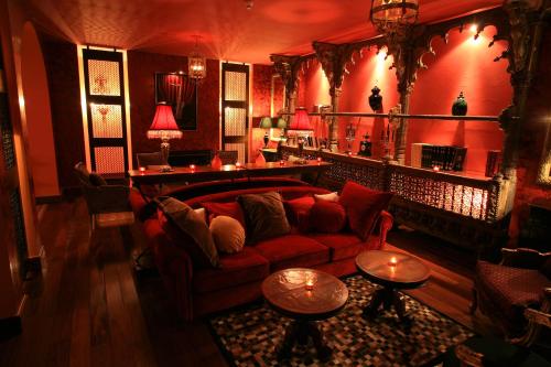 a living room with a couch and two tables at Hôtel Demeure Loredana in Saint-Florent