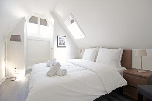 a white bedroom with a large white bed with two towels at Huge 3 bedroom apartment in Jordaan near CS in Amsterdam