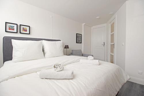 Una cama blanca con dos toallas encima. en Guesthouse Prinsencanal 2, en Ámsterdam