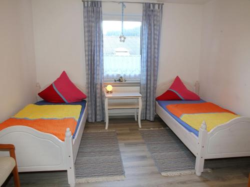 two beds in a small room with a window at Mangs-Hof in Plettenberg