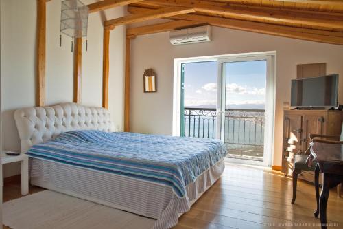 a bedroom with a bed and a large window at Villa Mos in Kalamata