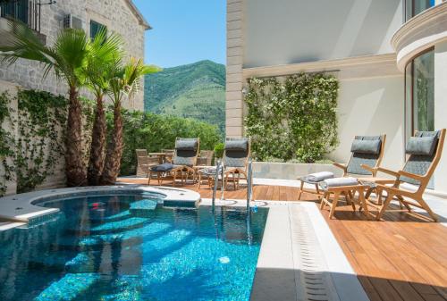 a swimming pool in a house with chairs and a patio at Hotel Forza Terra in Kotor