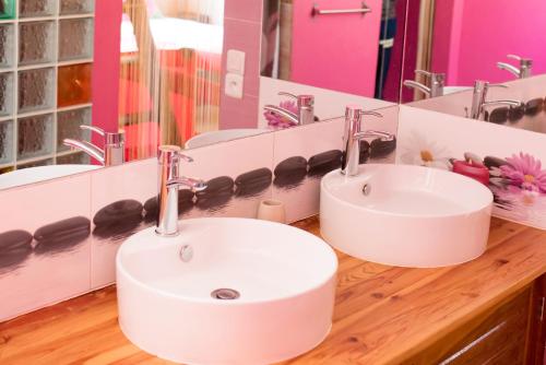 a bathroom with two sinks and a large mirror at Le Chateau du Lac de Mantasoa in Mantasoa