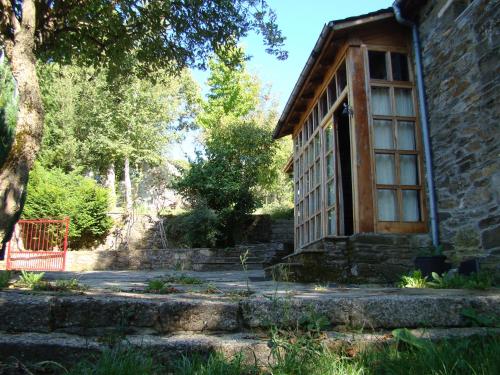 an old stone house with a large window at Casa dos Pedrouzos in Doncos