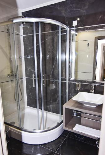 ein Badezimmer mit Glasdusche und Waschbecken in der Unterkunft Hotel Ključ in Ključ