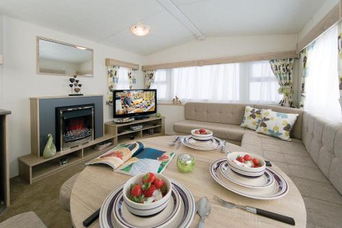 a living room with a table and a couch at Marine Holiday Park in Rhyl