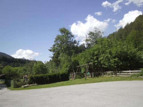 a field with a tree and a swing at Ferienwohnung Kirchbrücke in Mieders