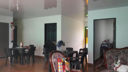 a dining room with tables and chairs in a room at Hostal Casa de Los Taitas in Salento