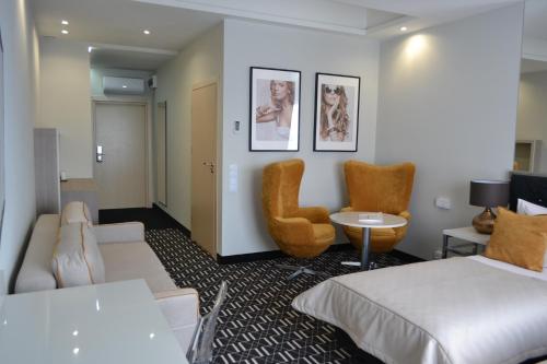 a hotel room with two beds and a chair at Hotel Atelia in Lublin