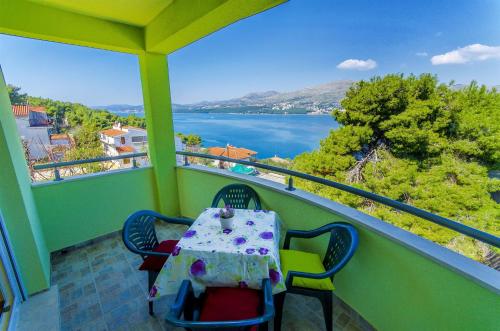 una mesa y sillas en un balcón con vistas al agua en Apartments Pava, en Okrug Donji