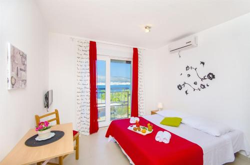 1 dormitorio con cama, mesa y ventana en Apartments Pava, en Okrug Donji