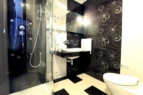 a bathroom with a shower and a toilet and a sink at Ambiance Hotel in Bucharest