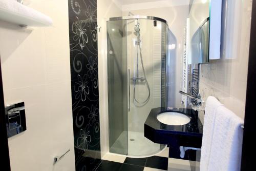 a bathroom with a glass shower and a sink at Ambiance Hotel in Bucharest