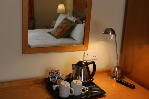 a desk with a mirror and a cup on it at Horizon Hotel in Ayr