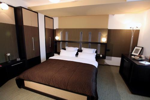 a hotel room with a large bed with white pillows at Ambiance Hotel in Bucharest