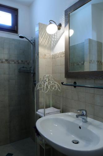 a bathroom with a sink and a mirror and a shower at Il Borgo Delle Querce Villa Fichi Piscina privata in Martina Franca