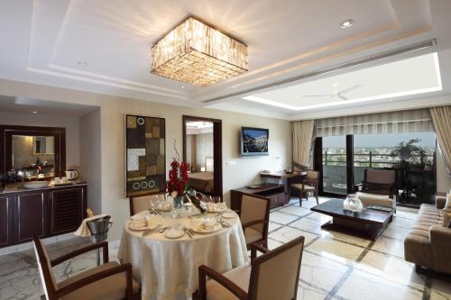 a living room with a table and a dining room at Jaypee Vasant Continental in New Delhi