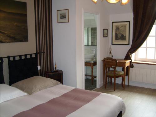 1 dormitorio con cama, escritorio y silla en Maison des Isles, en Saint-Hilaire-du-Harcouët