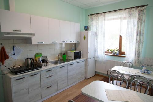 La cuisine est équipée de placards blancs et d'un réfrigérateur blanc. dans l'établissement AlekSelena, à Malekhuv