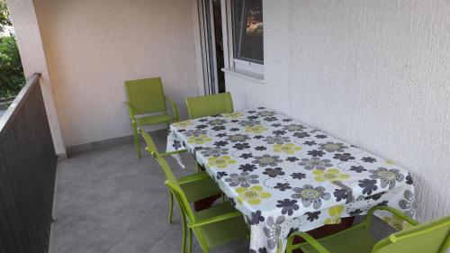 a table and chairs in a balcony with a table and a table cloth at Apartment Branko in Vinišće
