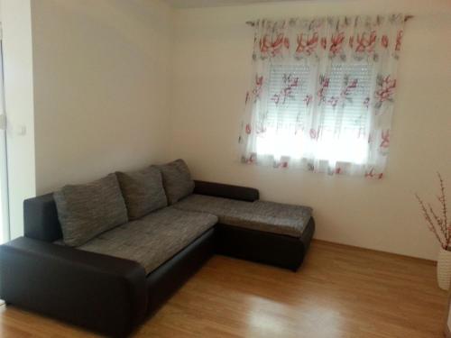 a couch in a living room with a window at Apartment Branko in Vinišće