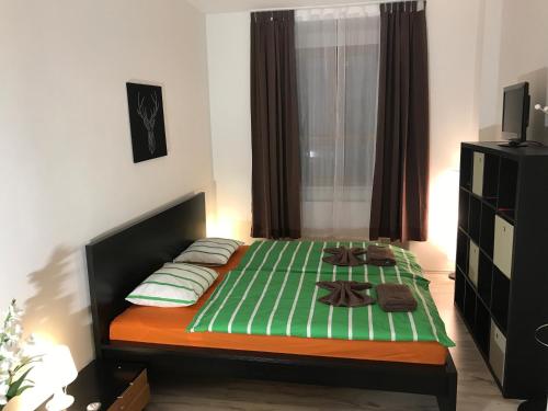 a bedroom with a bed with green sheets and pillows at Big Homebase with Billardtable in Prague