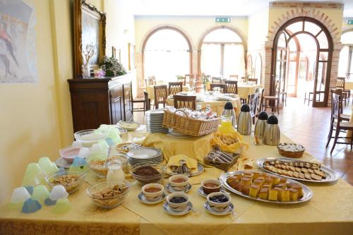 a table with a bunch of food on it at Hotel Funtana Noa in Villanovaforru