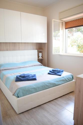 a bedroom with a bed with blue towels on it at Stefy Home in Catania