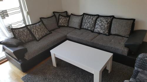 a couch with pillows and a table in a living room at Zebra in Podgorica