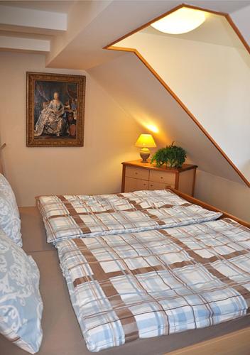 a bedroom with a bed and a painting on the wall at Apartmány Rosalka in Stará Oleška