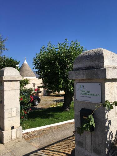 ein Steindenkmal mit einem Schild im Hof in der Unterkunft Trulli di Pozzomasiello in Locorotondo