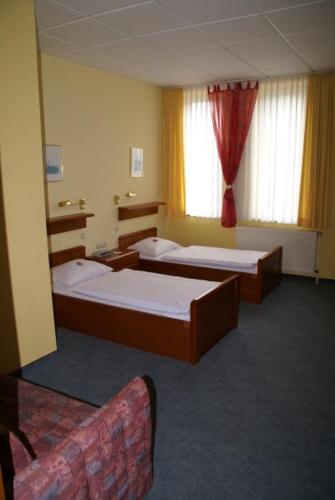 a hotel room with two beds and a couch at Weser Wasserbetten Hotel Baxmann in Hessisch Oldendorf