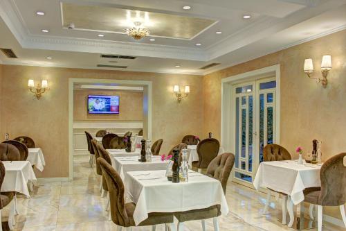a restaurant with tables and chairs and a tv at Lot Boutique Hotel by Hotels and Preference in Tirana