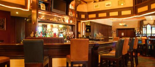 a bar in a restaurant with chairs and a counter at Feerick's Hotel in Rathowen