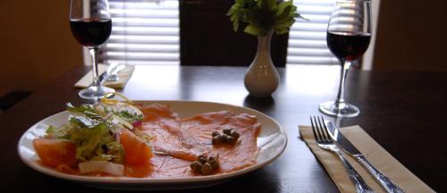 une assiette de nourriture sur une table avec deux verres de vin dans l'établissement Feerick's Hotel, à Rathowen