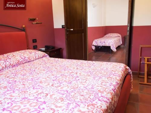 a bedroom with a bed with a pink and white bedspread at Agriturismo Antica Sosta in Viterbo