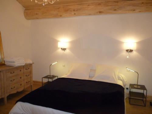 1 dormitorio con 1 cama con 2 luces en la pared en Le Mazot, en Villaroger