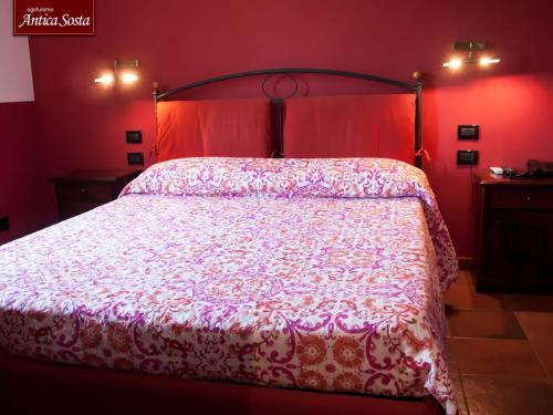 a bedroom with a large bed with a red wall at Agriturismo Antica Sosta in Viterbo