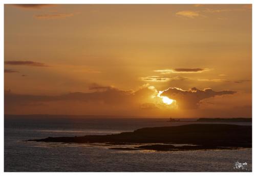 a sunset over the ocean with the sun setting at Tigh Fitz Apartments - Inis Mór, Aran Island in Inis Mor