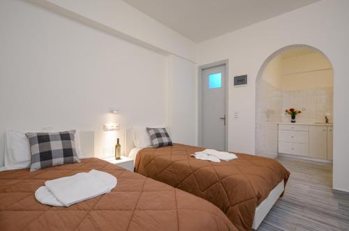 a white room with two beds and a kitchen at Soula Naxos in Naxos Chora