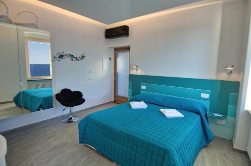 a bedroom with a blue bed and a black chair at Crêuza de Mä in Riomaggiore