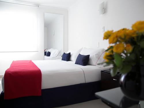 a bed room with a white bedspread and white pillows at Zalmedina Hotel in Cartagena de Indias