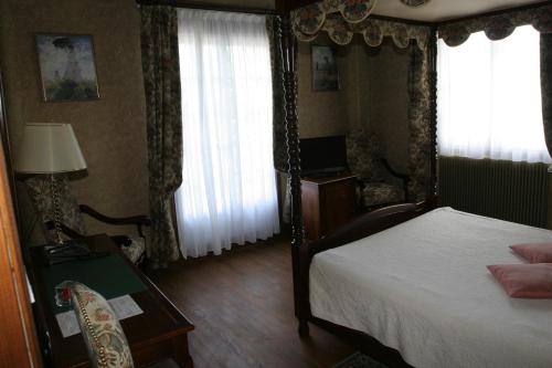 a bedroom with a bed and a table and window at Hotel Royal Albion in Mesnil-Val-Plage