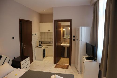 a small kitchen with a refrigerator and a sink at Prinos Mare in Prinos