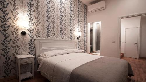 1 dormitorio con 1 cama y papel pintado con motivos florales en Domus Iuliae en Roma